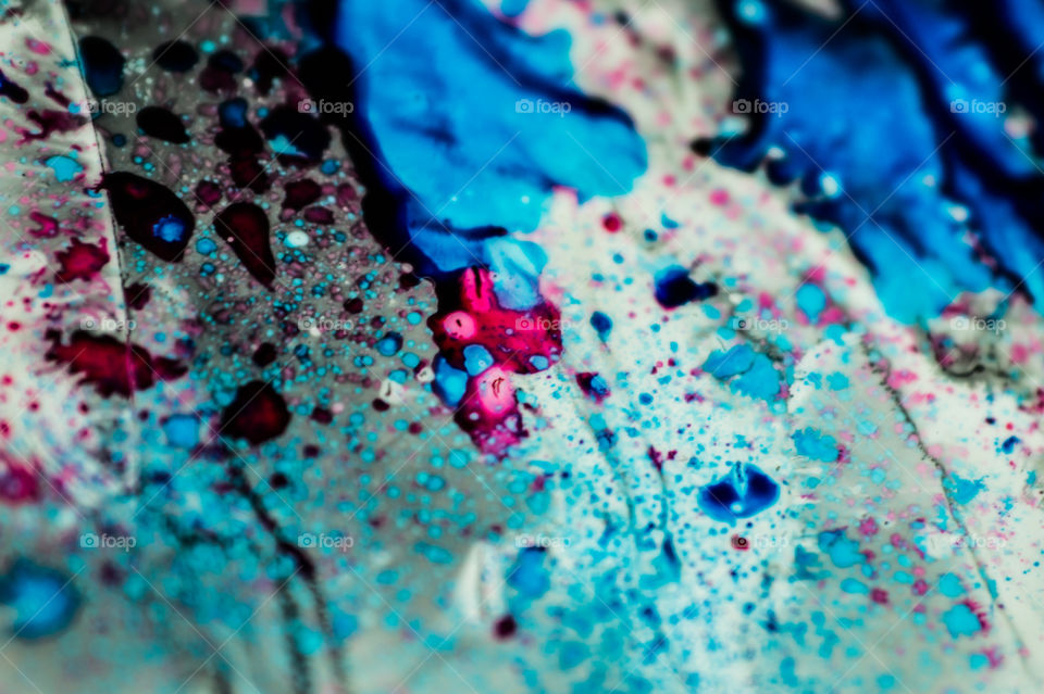 The ink to refill the printer cartridge was spilled onto the white washbasin and the paints blended into abstract drips and patterns.