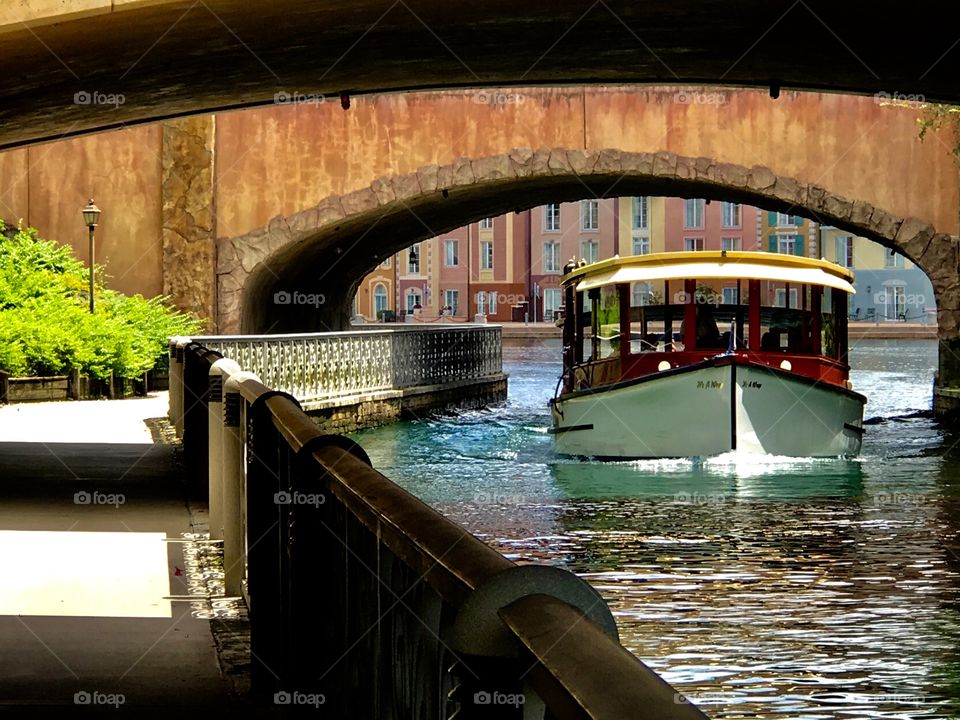 Boat traveling under a bridge 