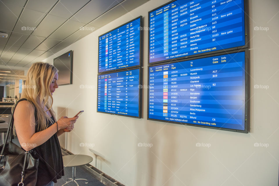 Woman looking at the flight board at Copenhagen airport.
