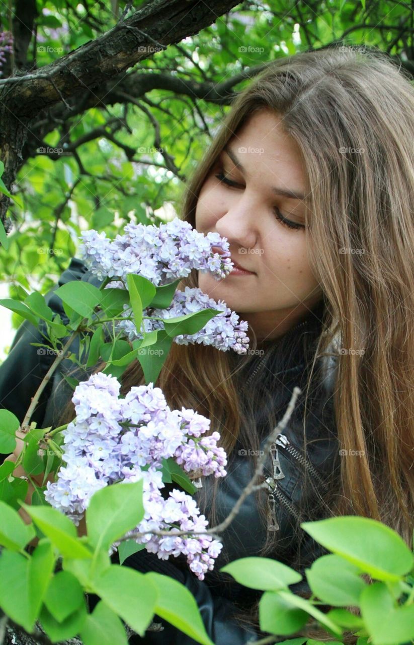 Beautiful girl is smelling lilac. Beautiful girl is smelling lilac. Enjoy spring