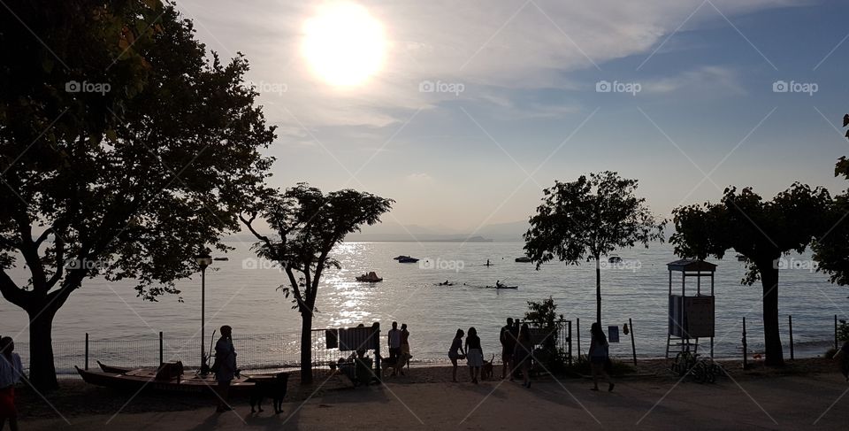 evening atmosphere at the lake in summer with walkers