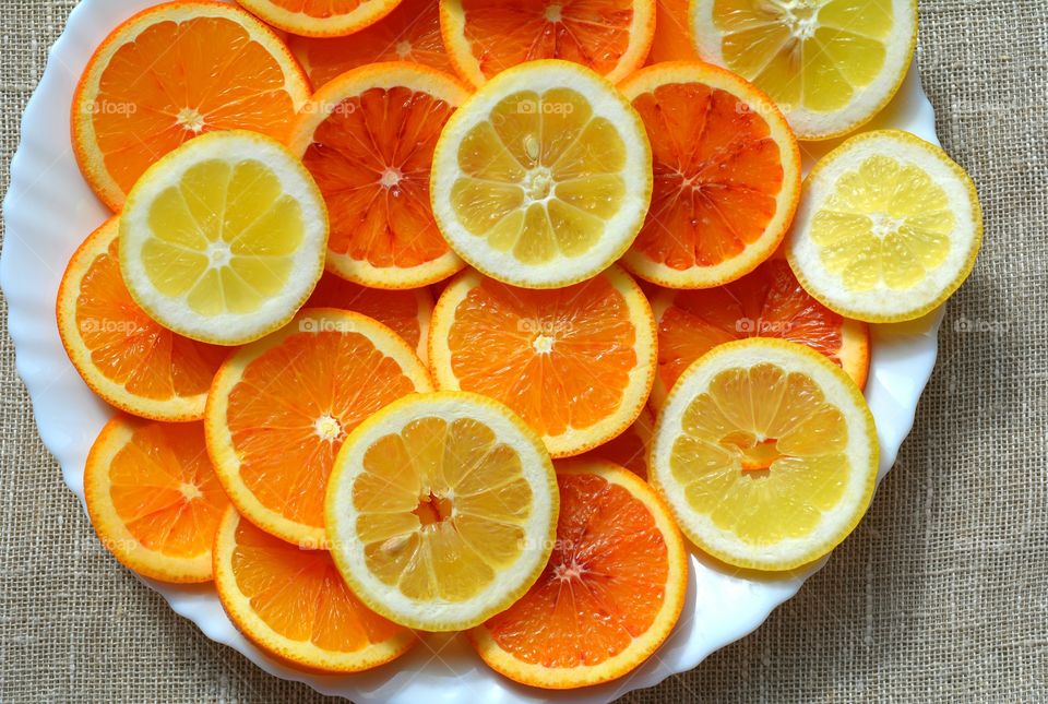 citrus sliced fruits on a plate texture background top view