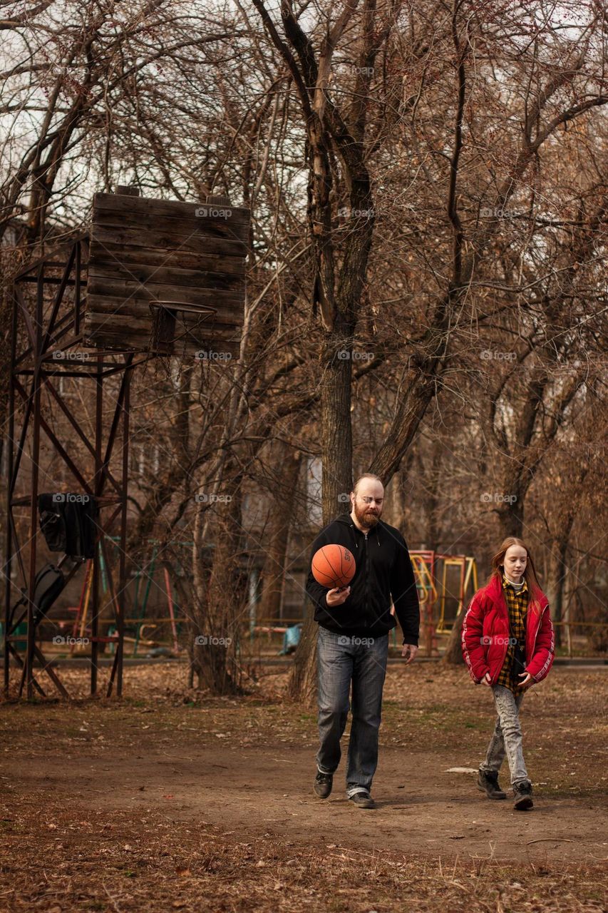 Father and daughter playing basketball in the yard