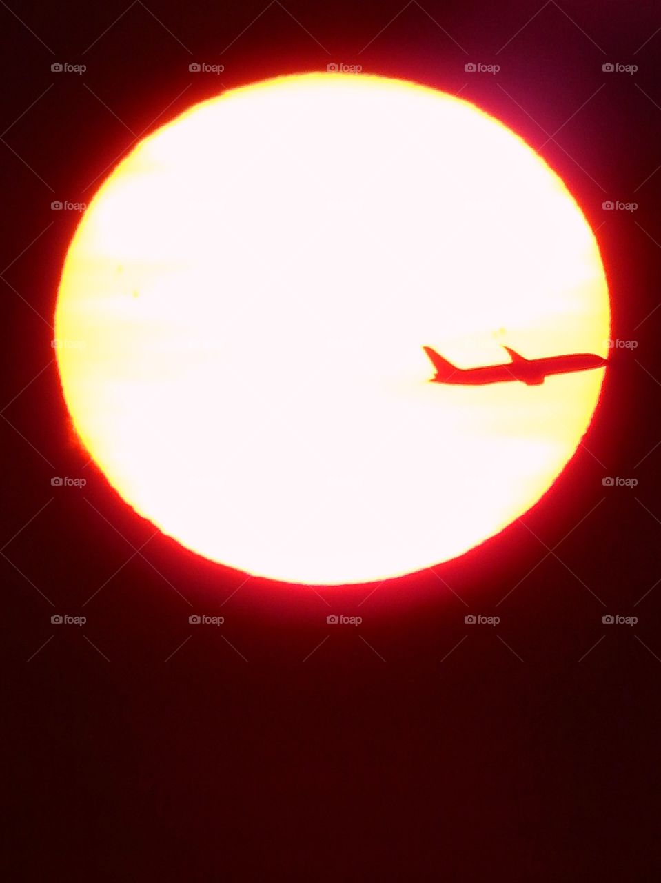 Airplane flying across the sun