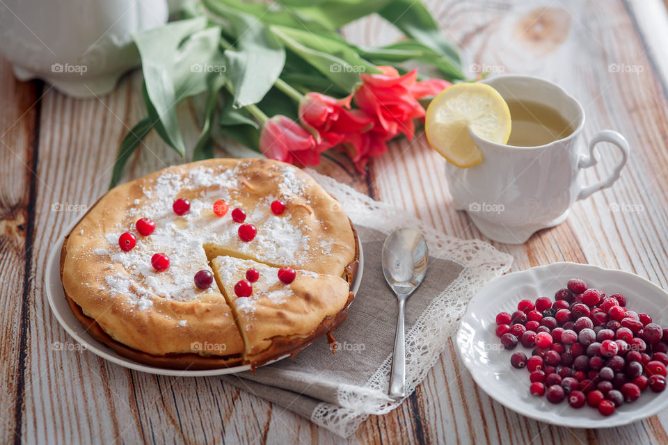 Cheesecake with cranberries and sugar on wooden background