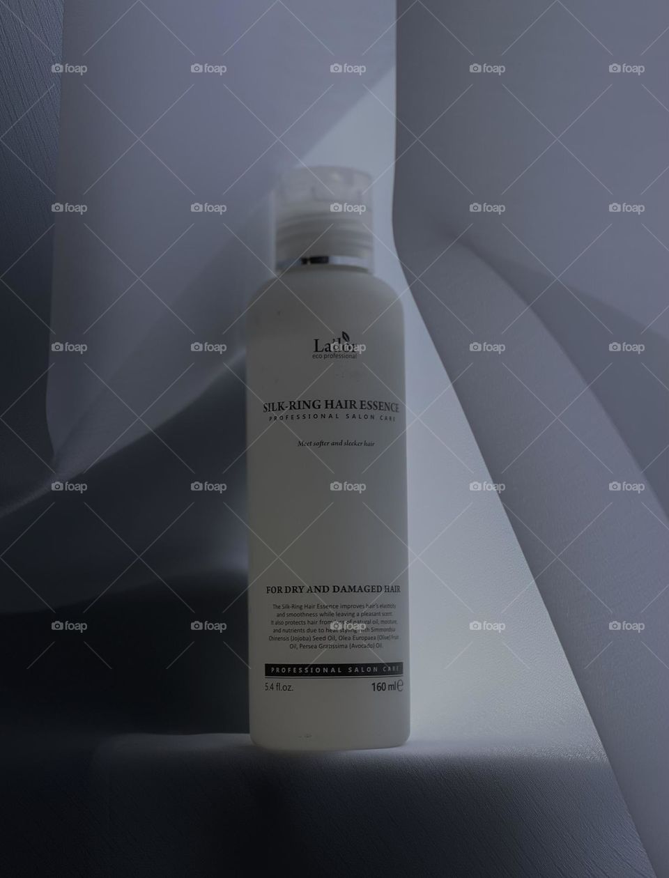 
In the photo, a sleek, minimalist hair product bottle is featured against a clean background. The label on the bottle is simple yet elegant, showcasing the name of the product and its key ingredients.