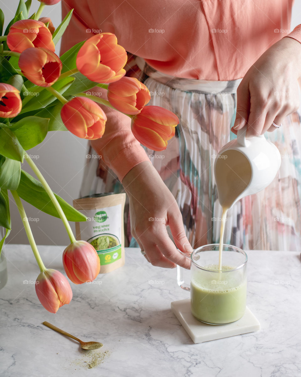 Pouring matcha tea in a glass