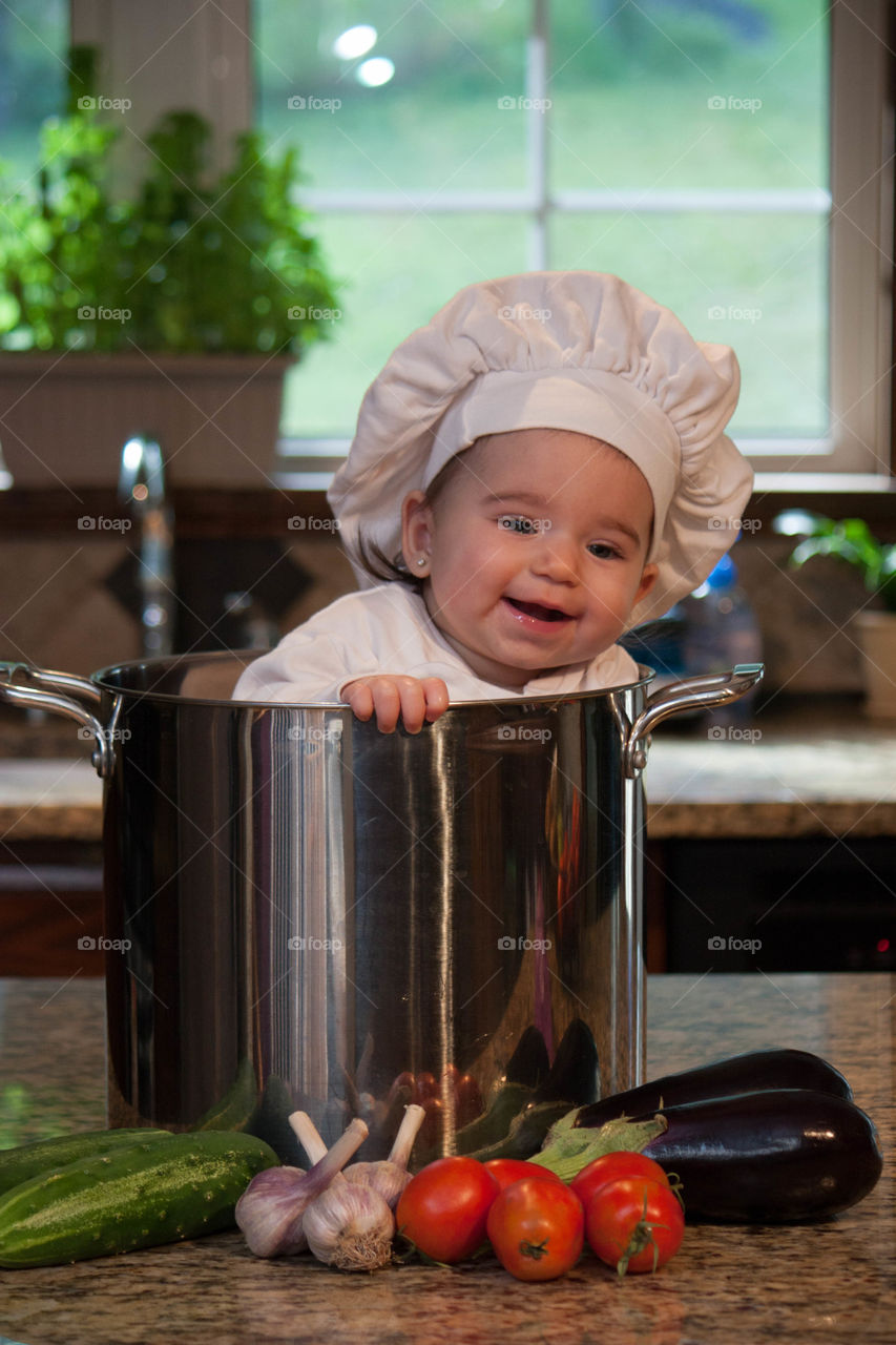 Cute baby chef in kitchen