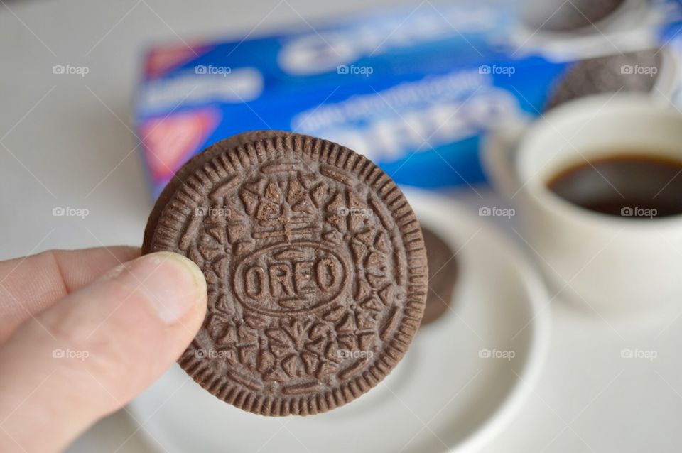 A persons fingers holding an Oreo cookie