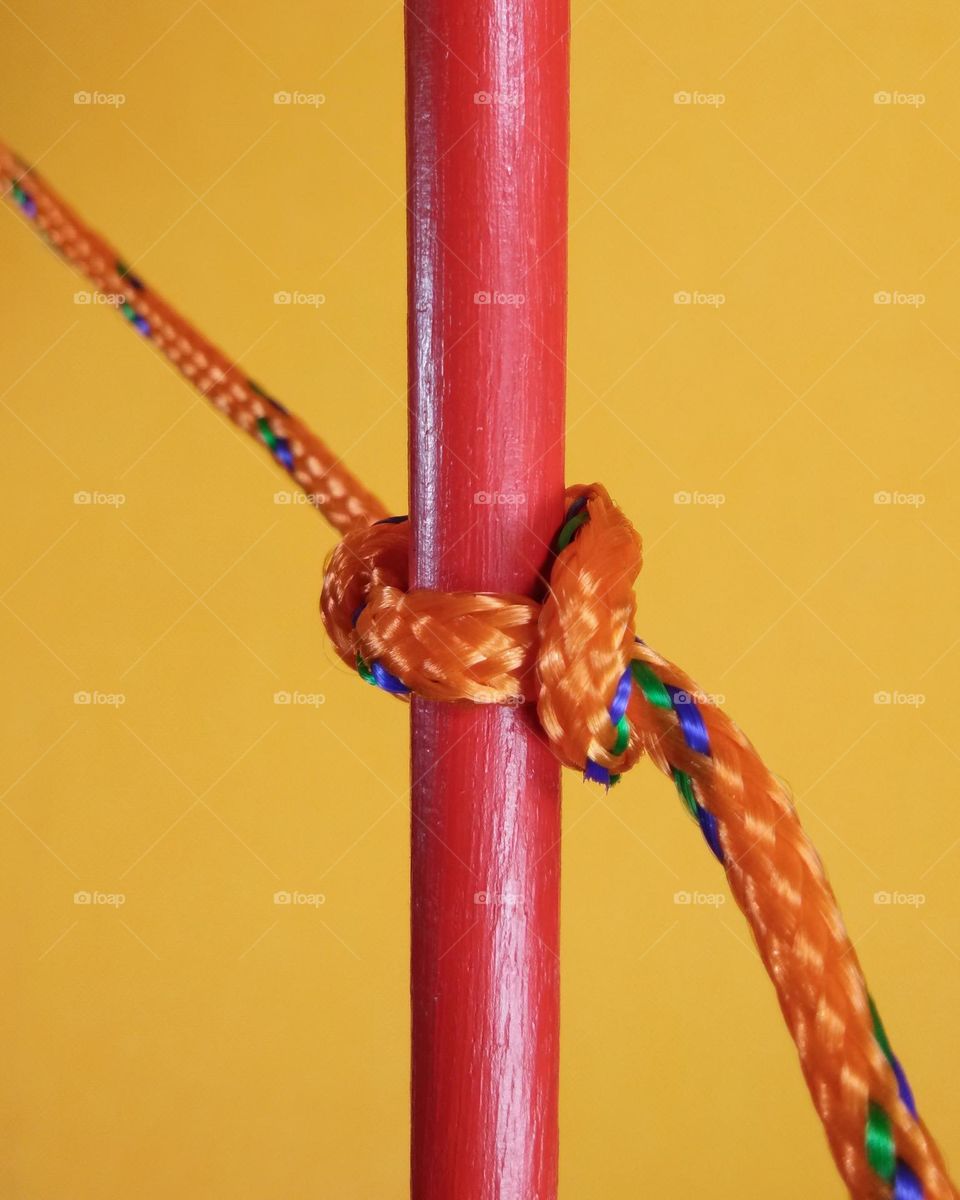 a stick bounded by colorful rope
