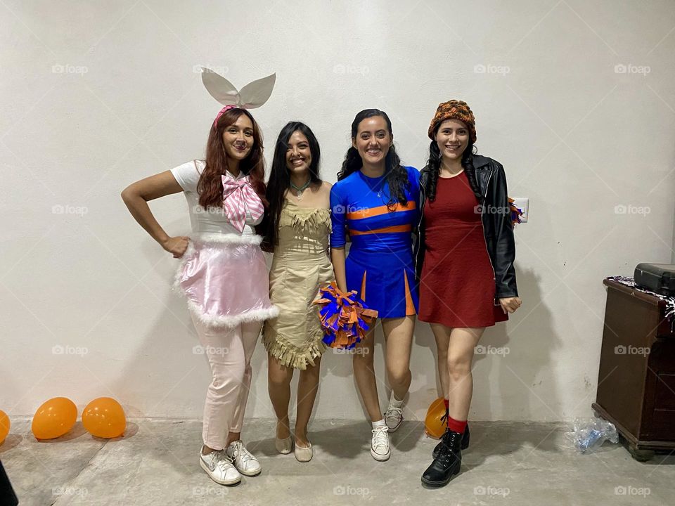 Group of women smiling and posing for a portrait, dressed with curious costumes.