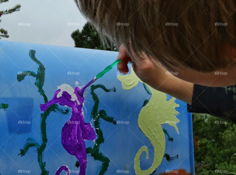 Child Painting A Picture. Young Boy Painting A Picture Of Seahorses
