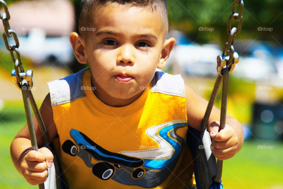 Close-up of a boy on swing in park