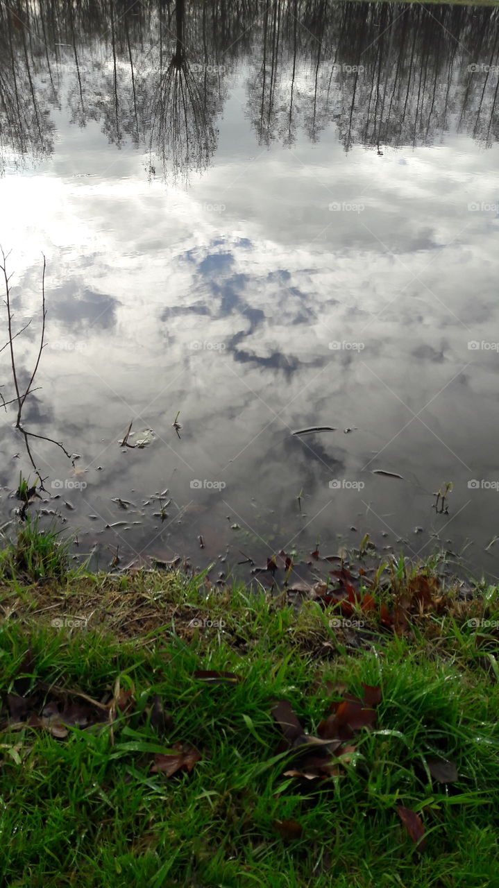 clear water reflection of clouds sky by a lake