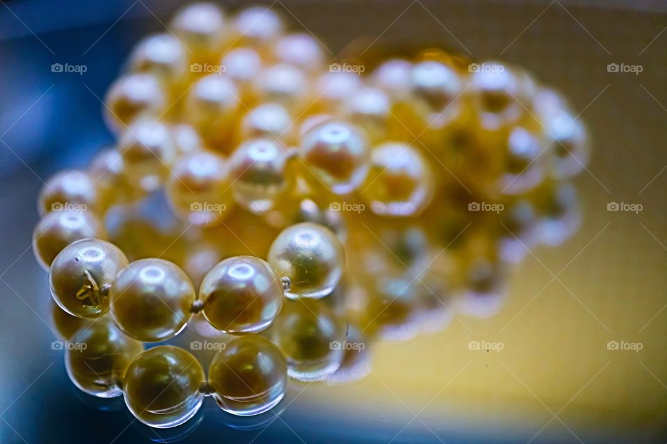 Beautiful pearl necklace relaxing on a mirrored surface showcasing the natural beauty of the pearl 