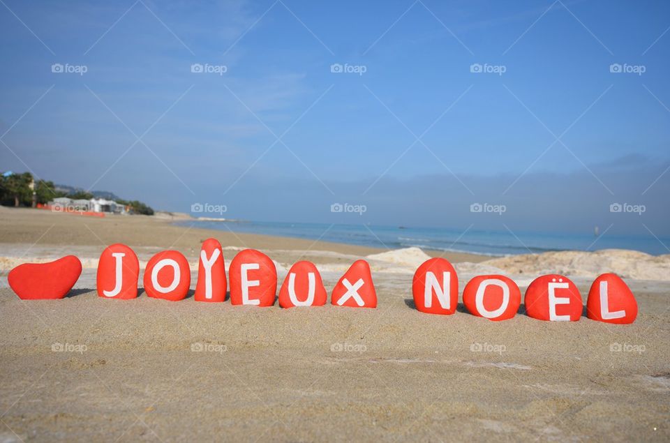 Joyeux Noël, red stones composition on the sand