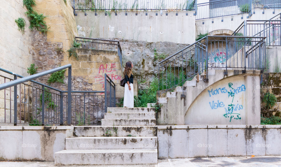 Woman standing on staircase of building at outdoors