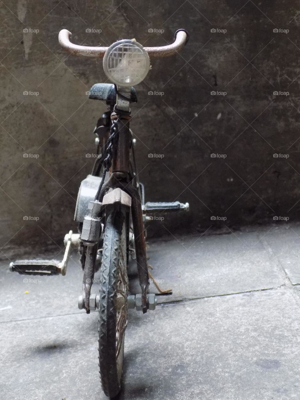 Old, rusty and broken toy bicycle