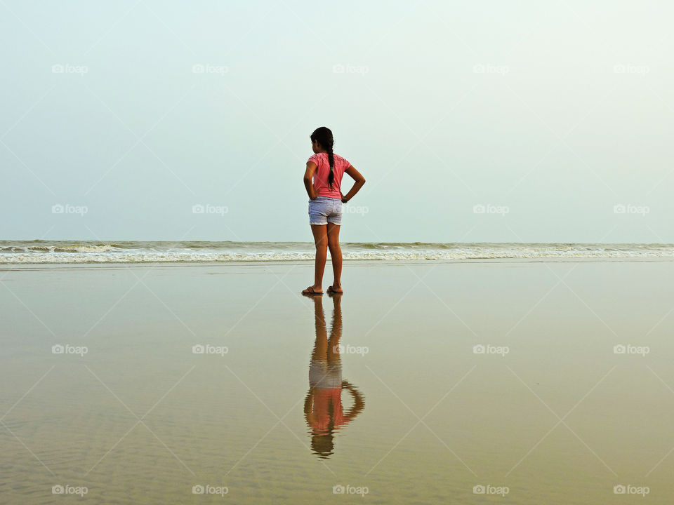 Girl standing on a sea beach