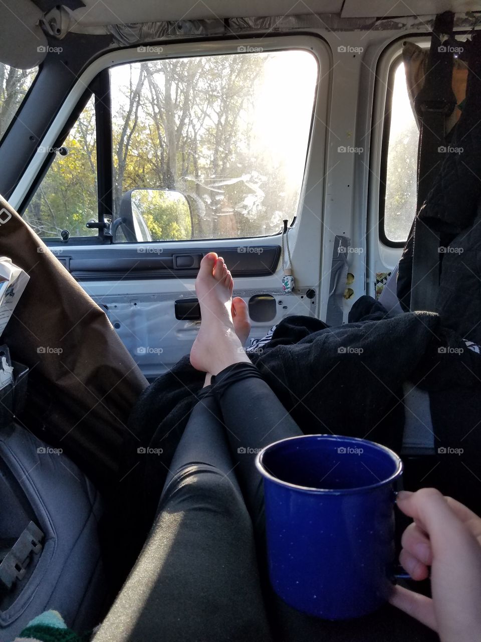 Enjoying a morning coffee in the front seats of a van.