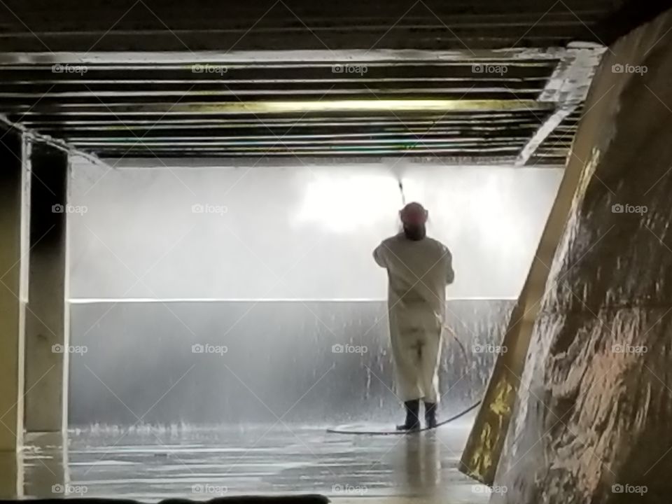 Pressure washing the fire & smoke damage from a car fire.