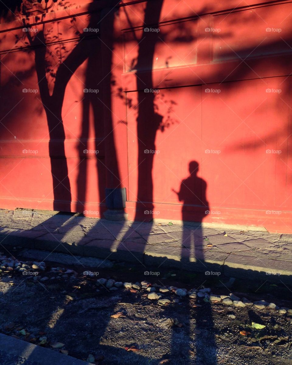 Solo traveller's shadow on the red wall 
