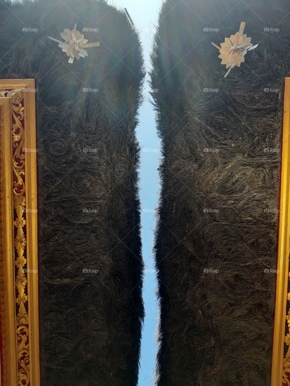 The blu sky act as a separation between two palm fiber roofs