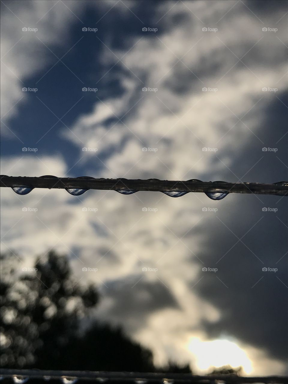 A few drops hangin on a washing line with a beautiful sky