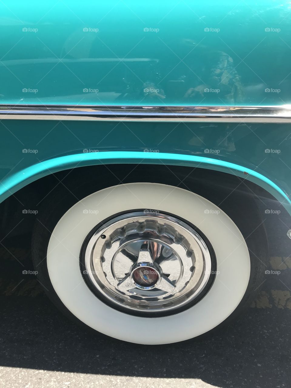 Turquoise vintage car white wall close up
