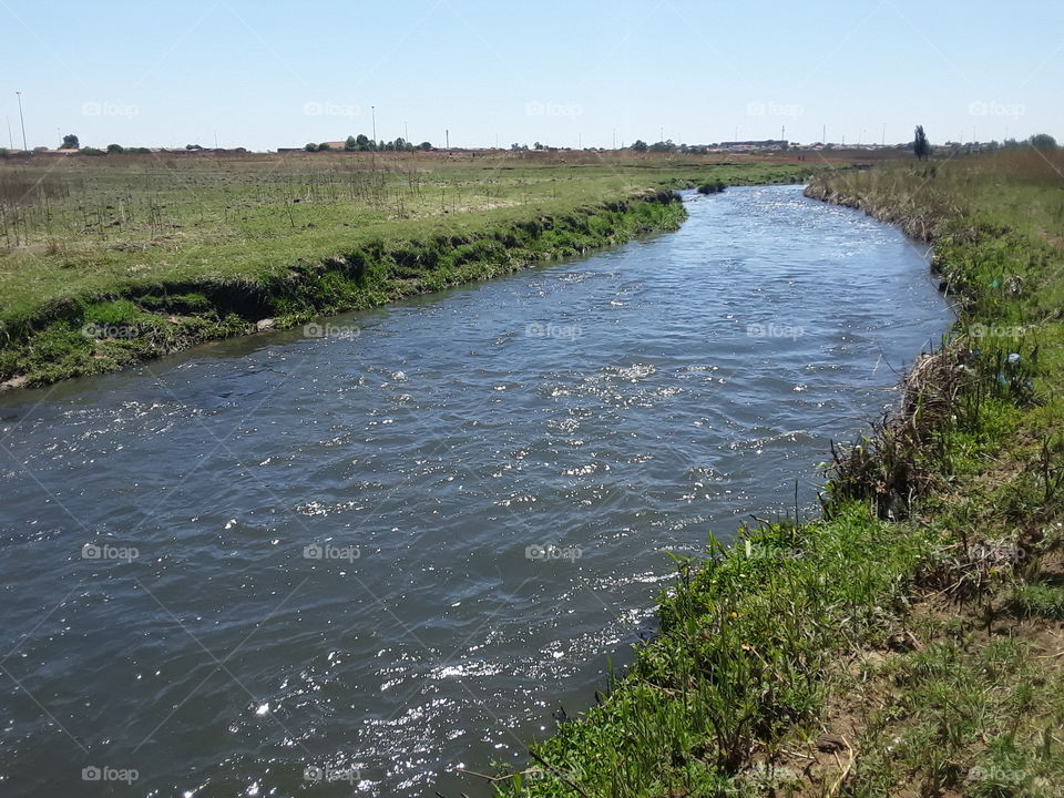 A wastewater from large factories make a deep river flow.