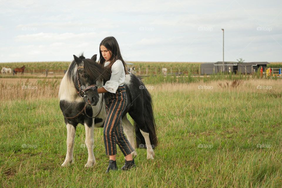 Teenage girl riding her horse in nature in the countryside