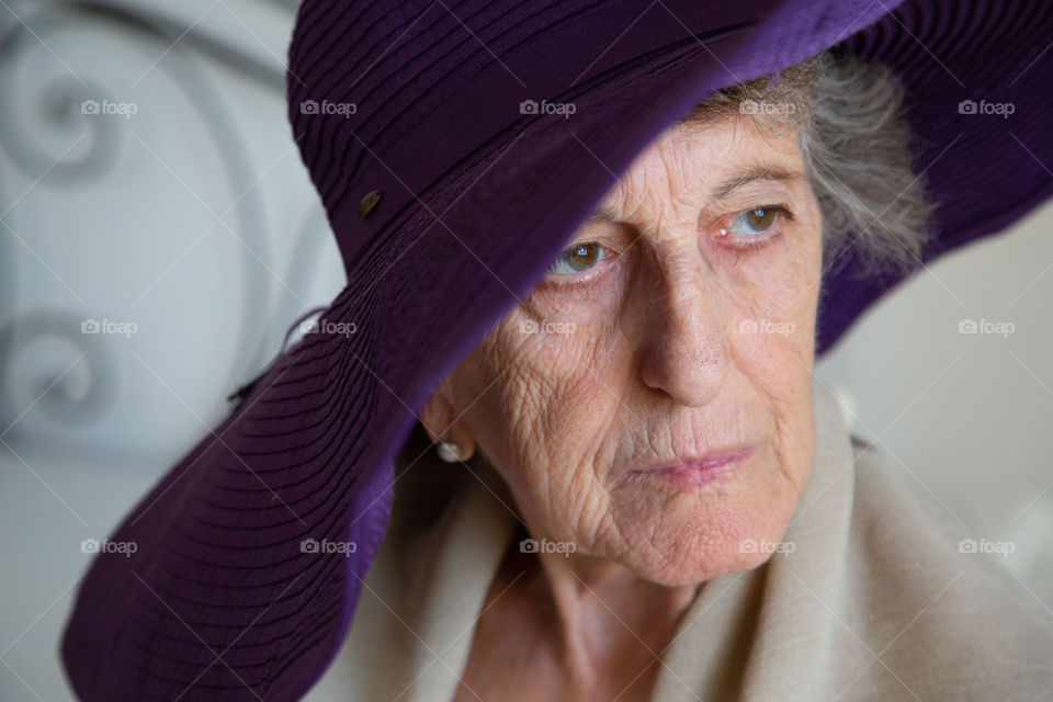 Senior woman in her 70s in the hat with wide brims.
