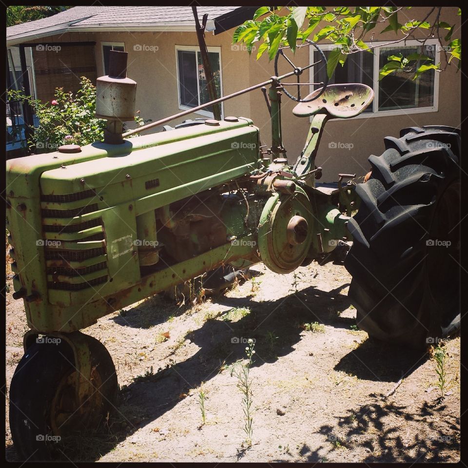 tractor in Paso Robles. a vintage green  tractor in a yard in Paso Robles, CA
