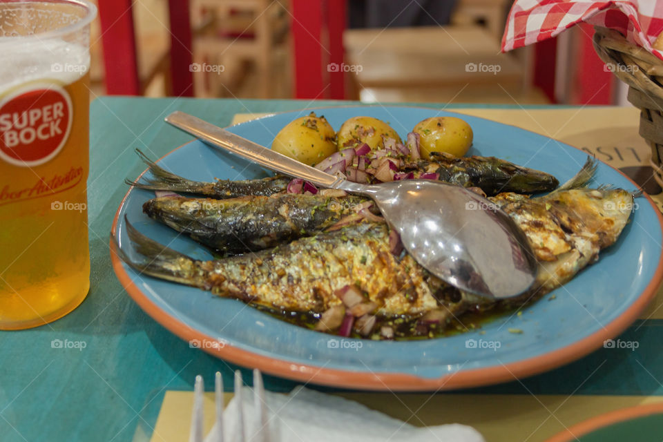 National Portuguese dish with fried fish,boiled potato and pickled onion