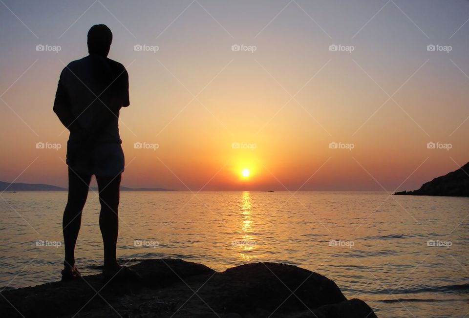 Silhouette of man watching the sunset