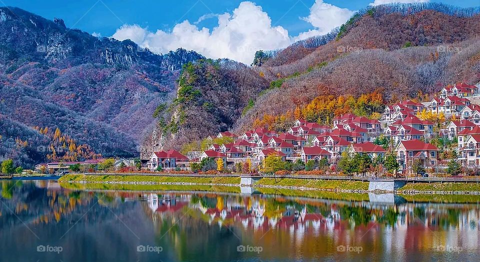 The image embodies a natural natural plate of the mountains of nature, where green agricultural stands are graded on the slopes as if they were lines of a poem, which fog harmoniously wrapped, and clouds hugged them in the mountain knife and the whis