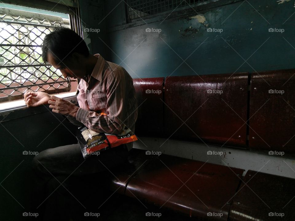 man in local train of Mumbai traveling for work ..in 2nd class