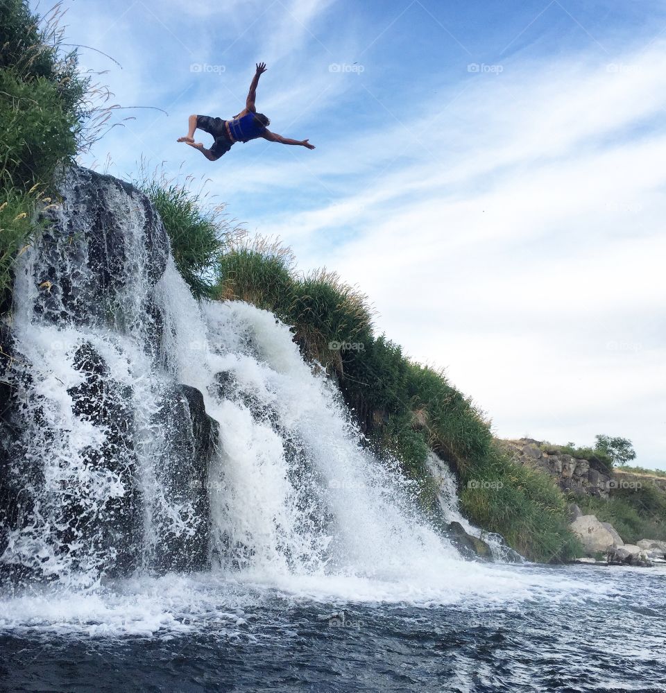 Man jumping in waterfall