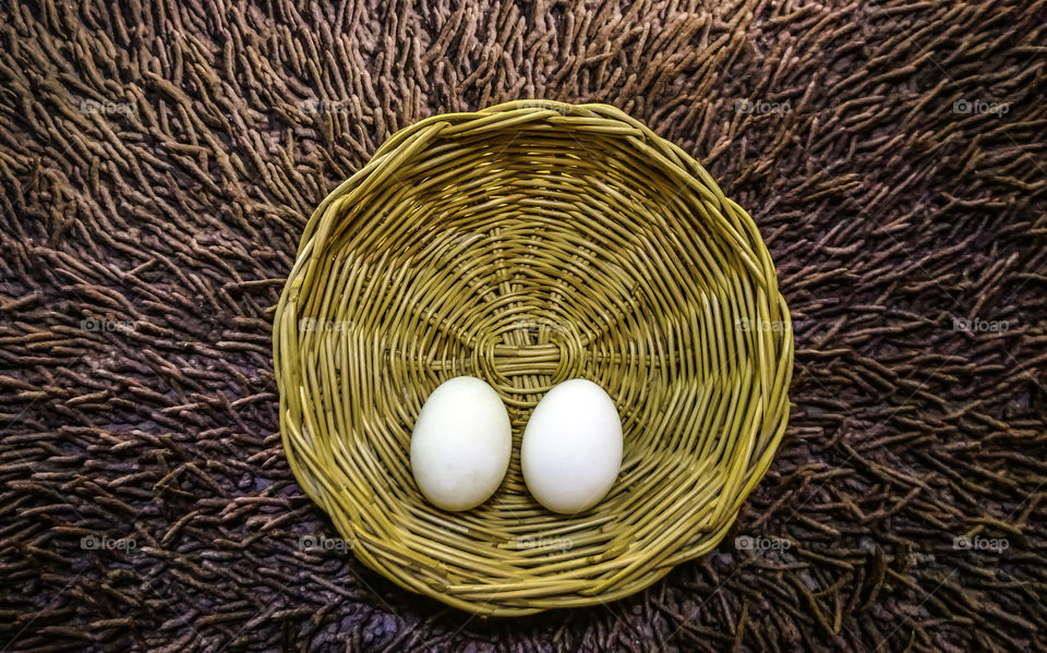 Two white egg in basket background