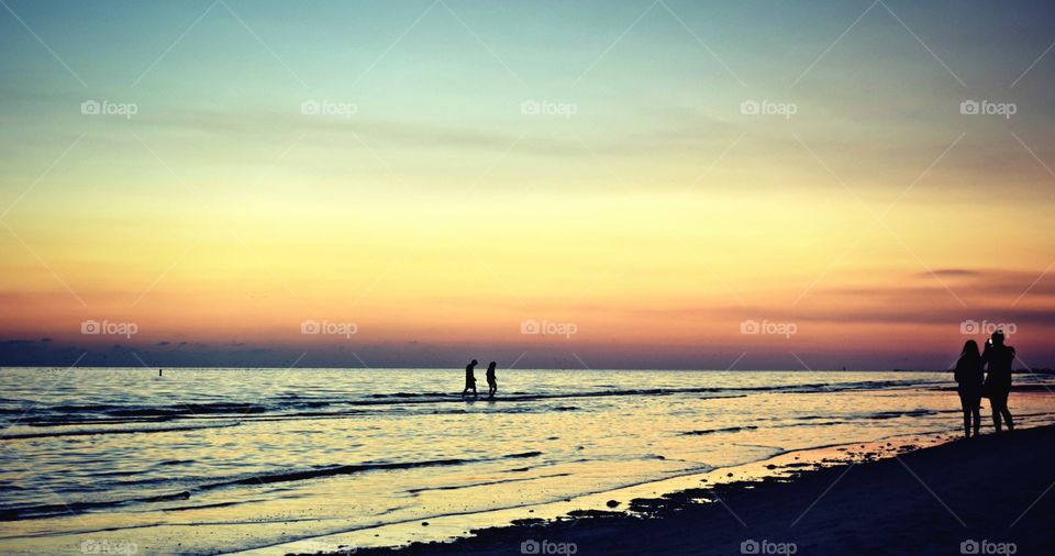 Silhouette of people at beach during sunset