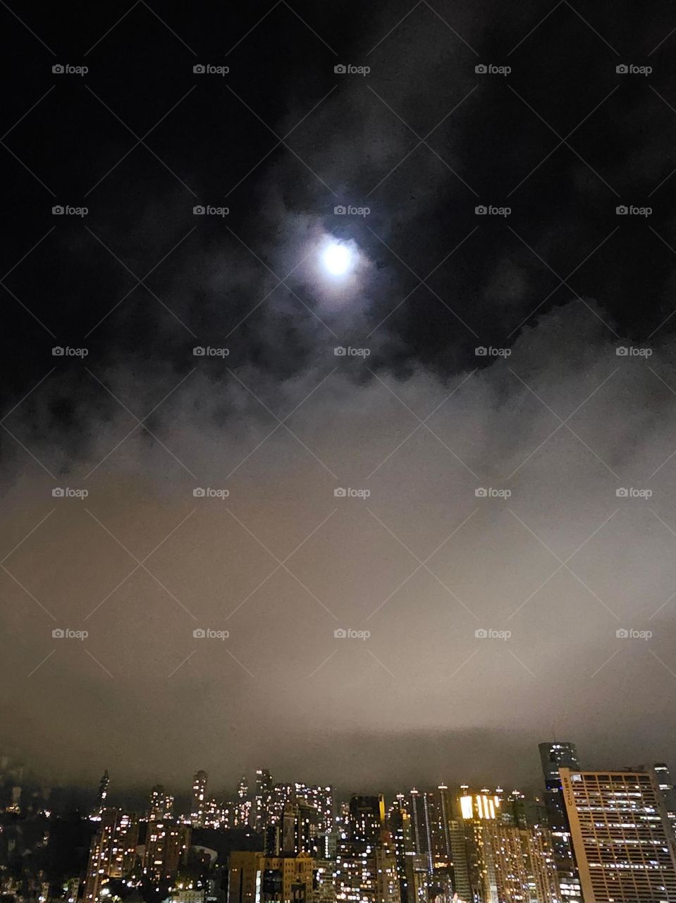 Cloudy night sky with the moon coming through