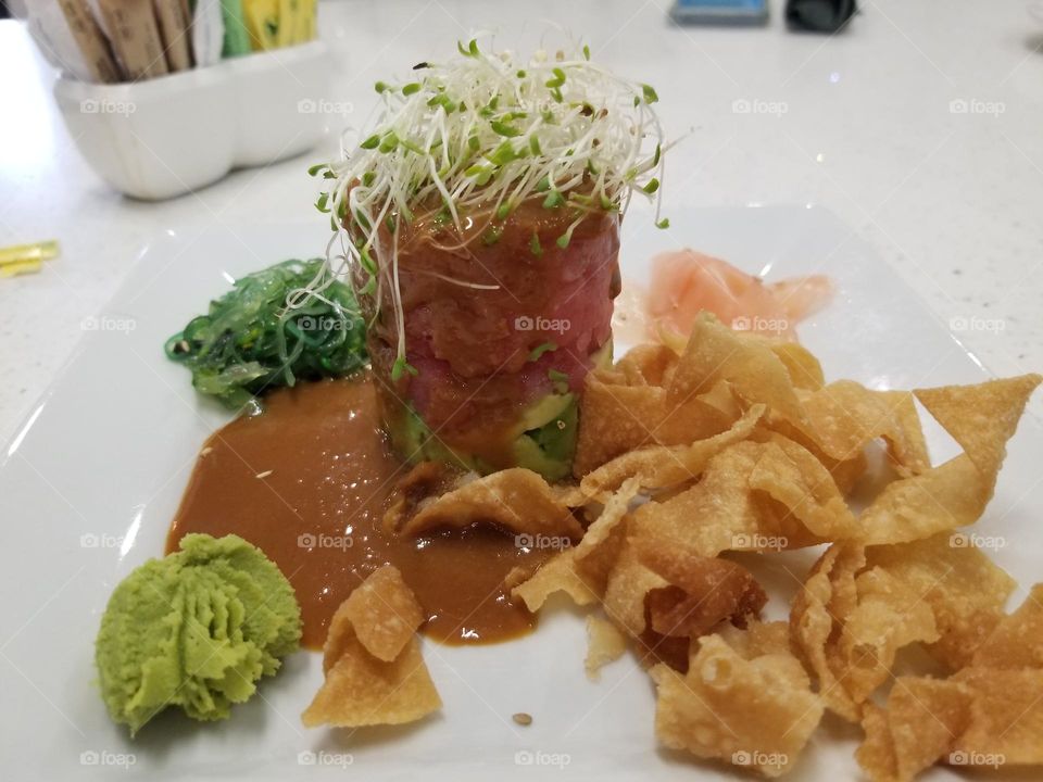 Ahi tuna tower with wonton chips, wasabi, pickled ginger, micro greens, avocado, absolutely delicious and flavorful appetizer