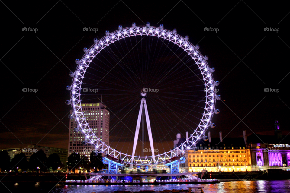 Illuminated London eye during night