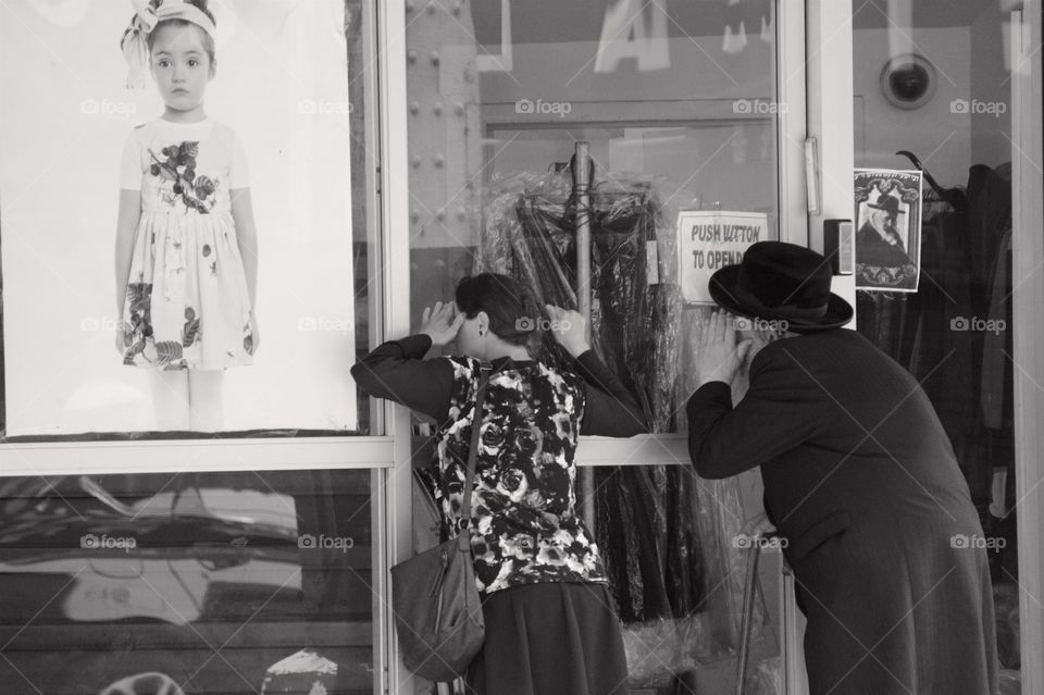 Jewish Hasidic man and woman looking into a store window in Borough Park, Brooklyn, NYC.