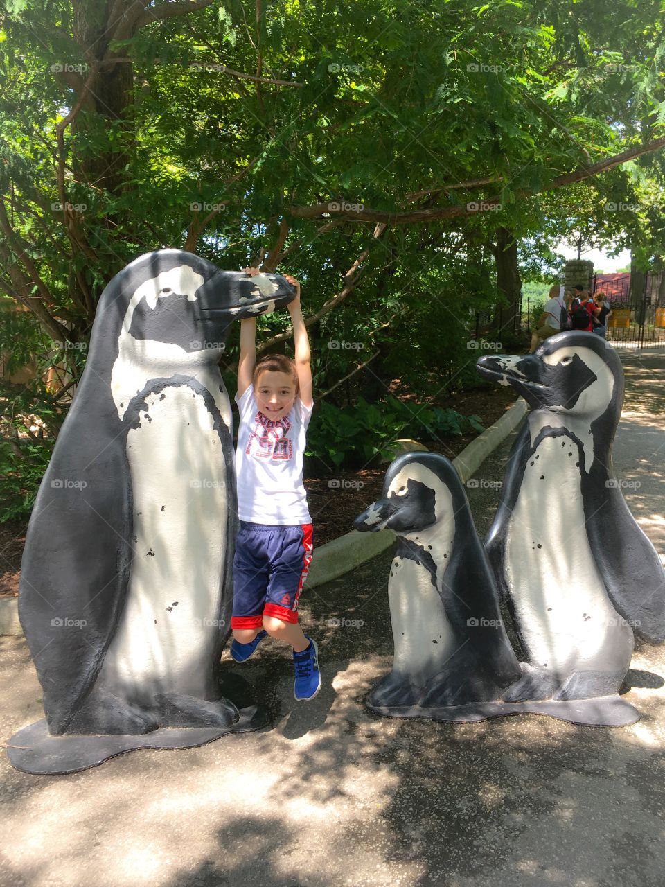 Happy kid spending a summer’s Sunday evening with his parents at the zoo! 
