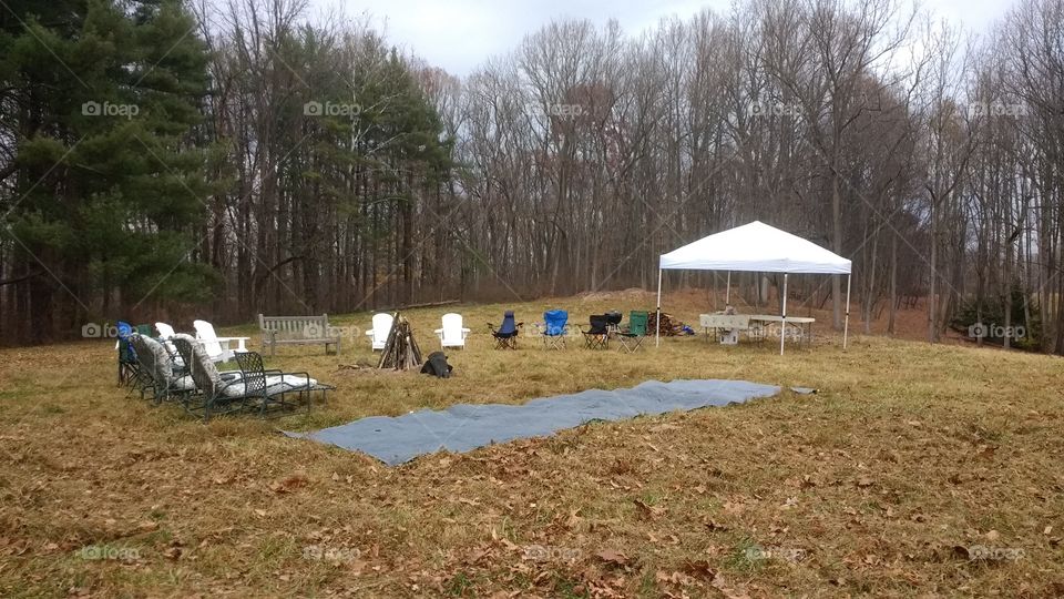 Outdoor rural tent and chairs set up for gathering and bonfire