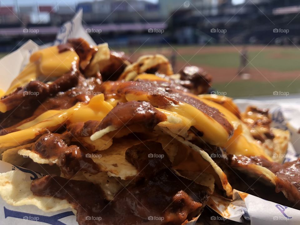 Nachos with nacho cheese and chili at a baseball game 