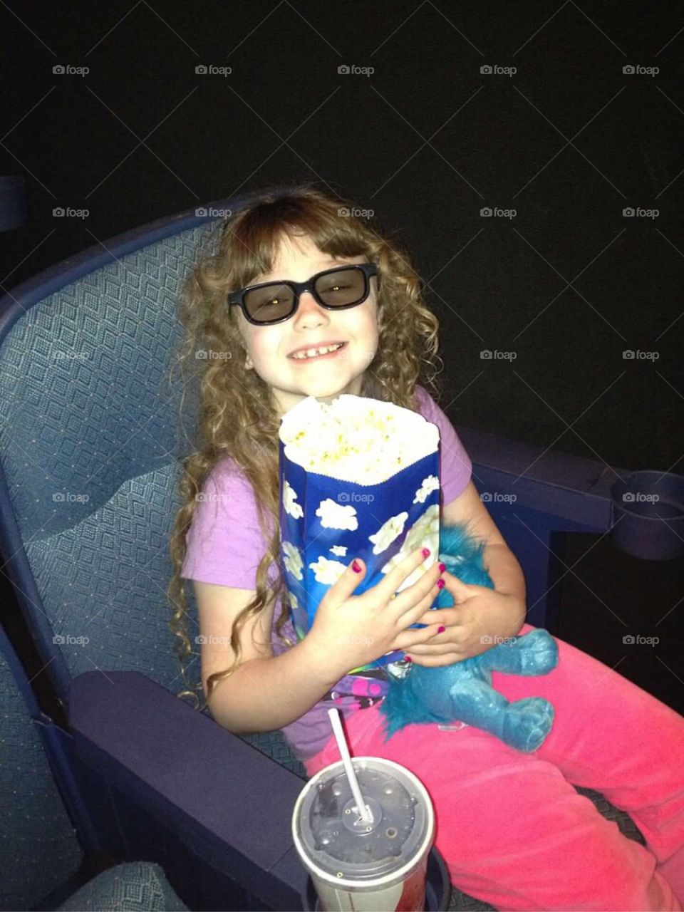 Girl in theater holding popcorns