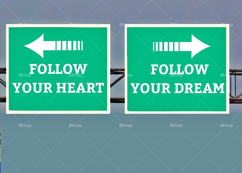 Green signpost with two opposite arrows pointing to follow your heart and follow your dream