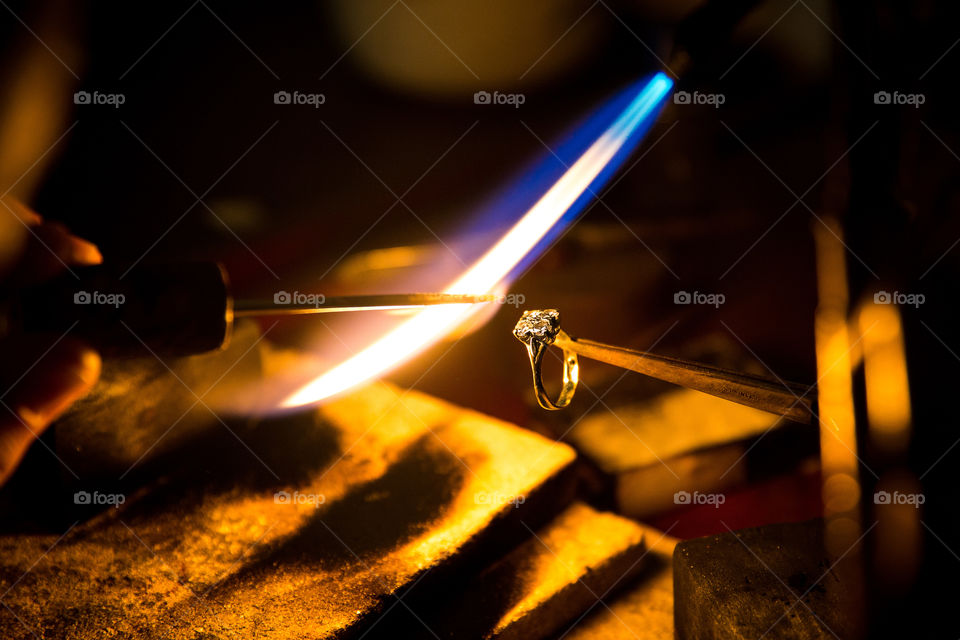 2019 a year of photos on foap! Image of man making ring with torch melting precious metals.